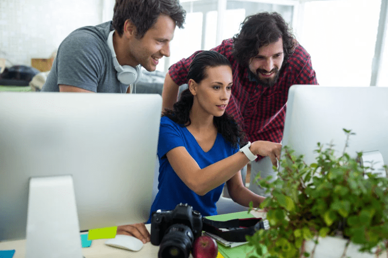 three people at computer using social media