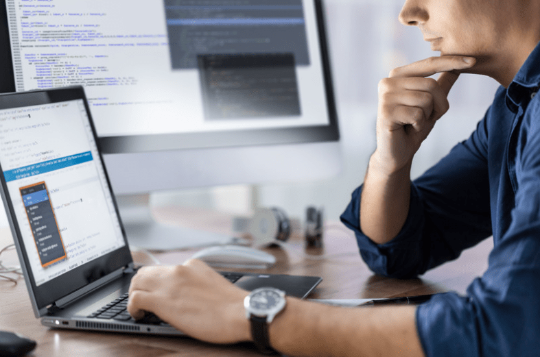 a man sitting at desk holding chin
